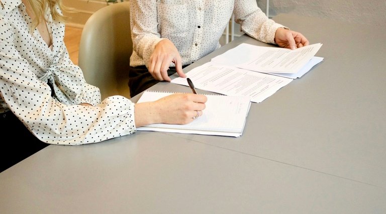 Salário-maternidade para empregada com carteira assinada Salário-maternidade para empregada com carteira assinada: Profissional analisa documentos trabalhistas durante consulta