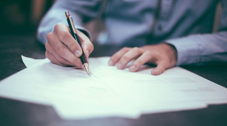 Pessoa assinando documentos de adoção ou guarda judicial para solicitar salário-maternidade